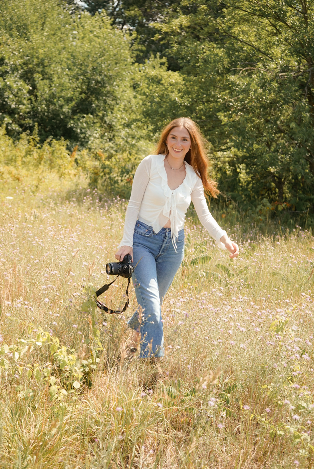 Lexus walking through a West Michigan field with her camera